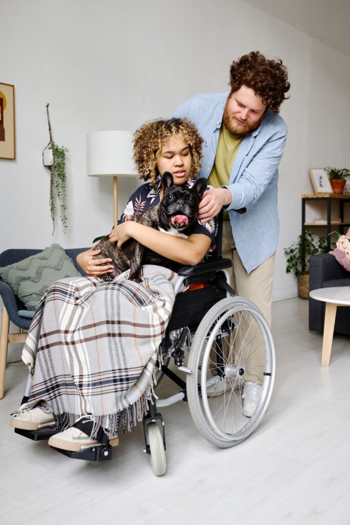 Young man caring about girl with disability at home